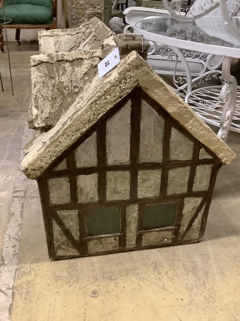 A reconstituted stone garden ornament, modelled as a Tudor cottage, width 86cm, depth 50cm, height 58cm